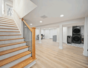 Bright finished space with wooden stairs and laundry area
